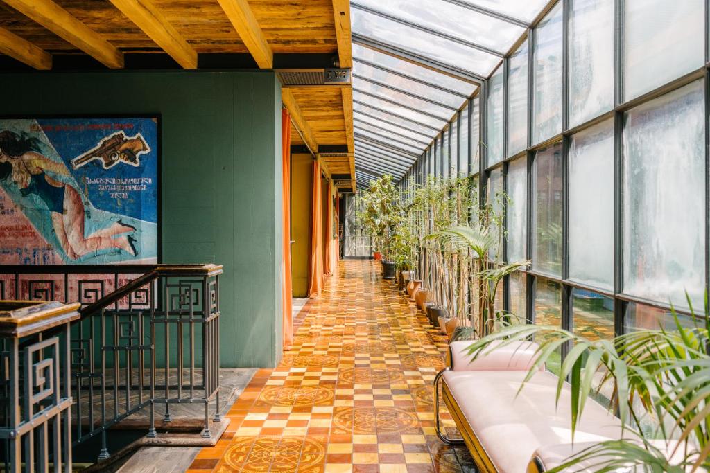 The lounge of Rooms Hotel Tbilisi in a former publishing house, with dark timber, leather chairs and tall windows.