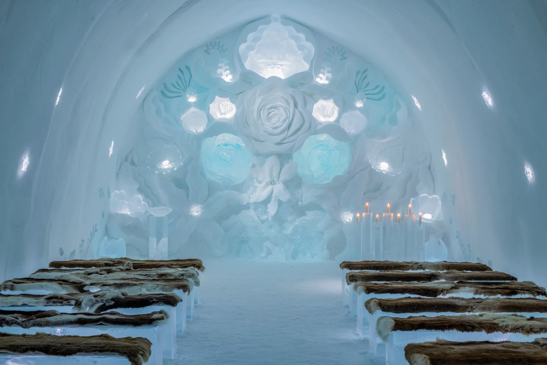 A carved ice suite at Icehotel in Jukkasjarvi, with a bed of ice blocks covered in reindeer hides.