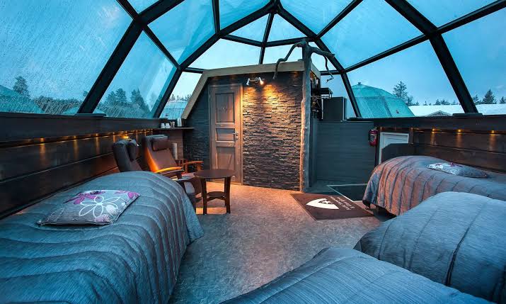 A snow room at Arctic SnowHotel near Rovaniemi, with a hide-covered ice bed and carved snow walls.